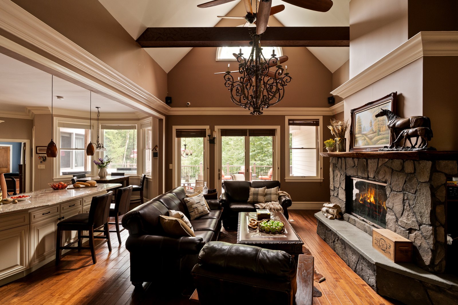 A beamed great room opening onto a kitchen island with bar seating.