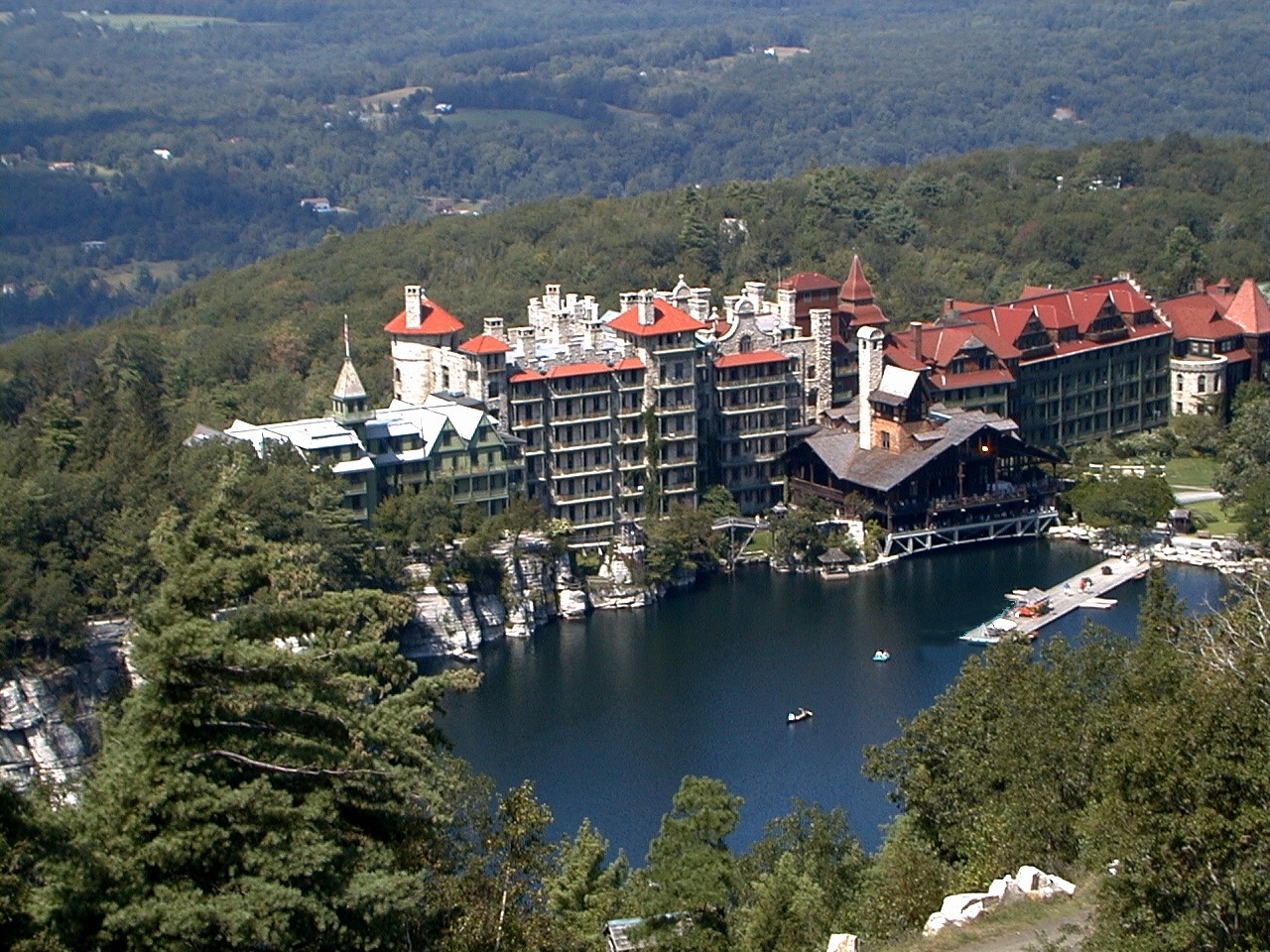 Mohonk Mountain House from above — the long Victorian lakefront, the lake, and the cliffs the resort opens onto