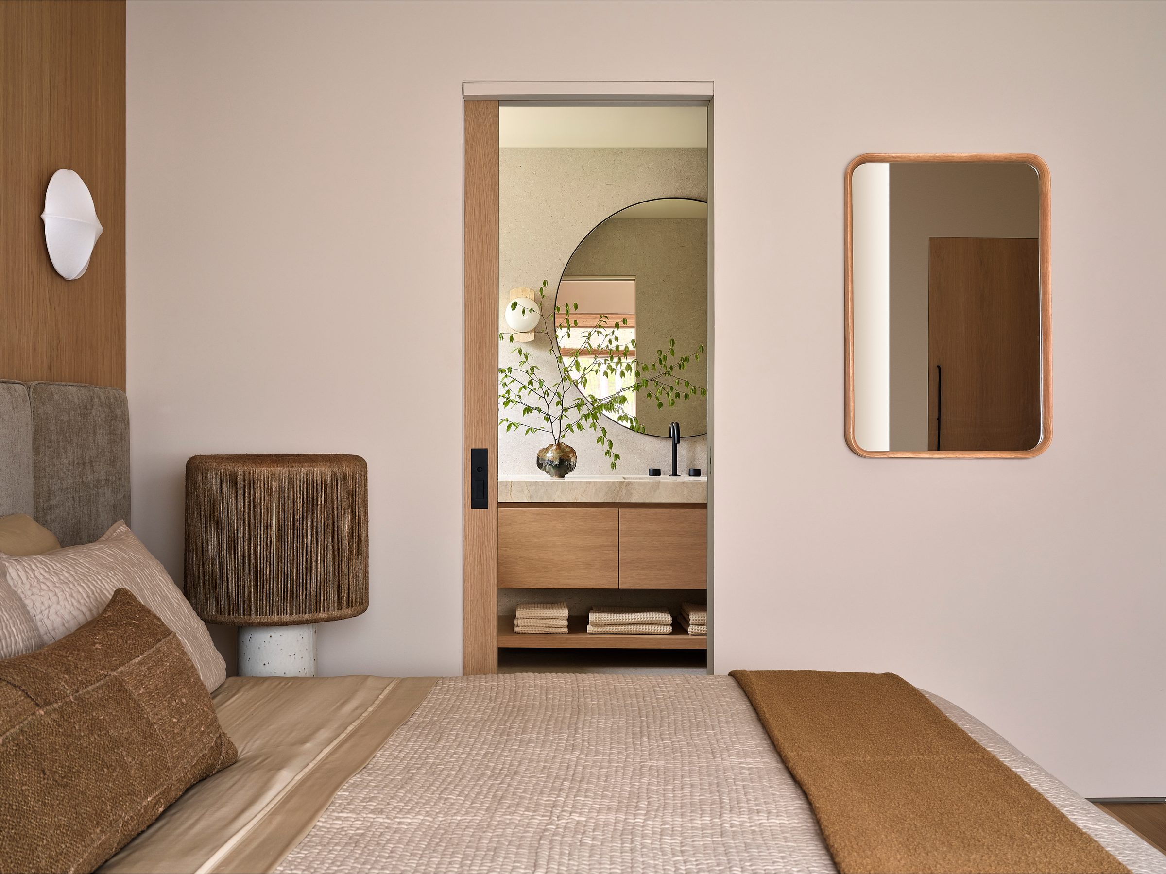 A bedroom corner with a view through a doorway into a bath.