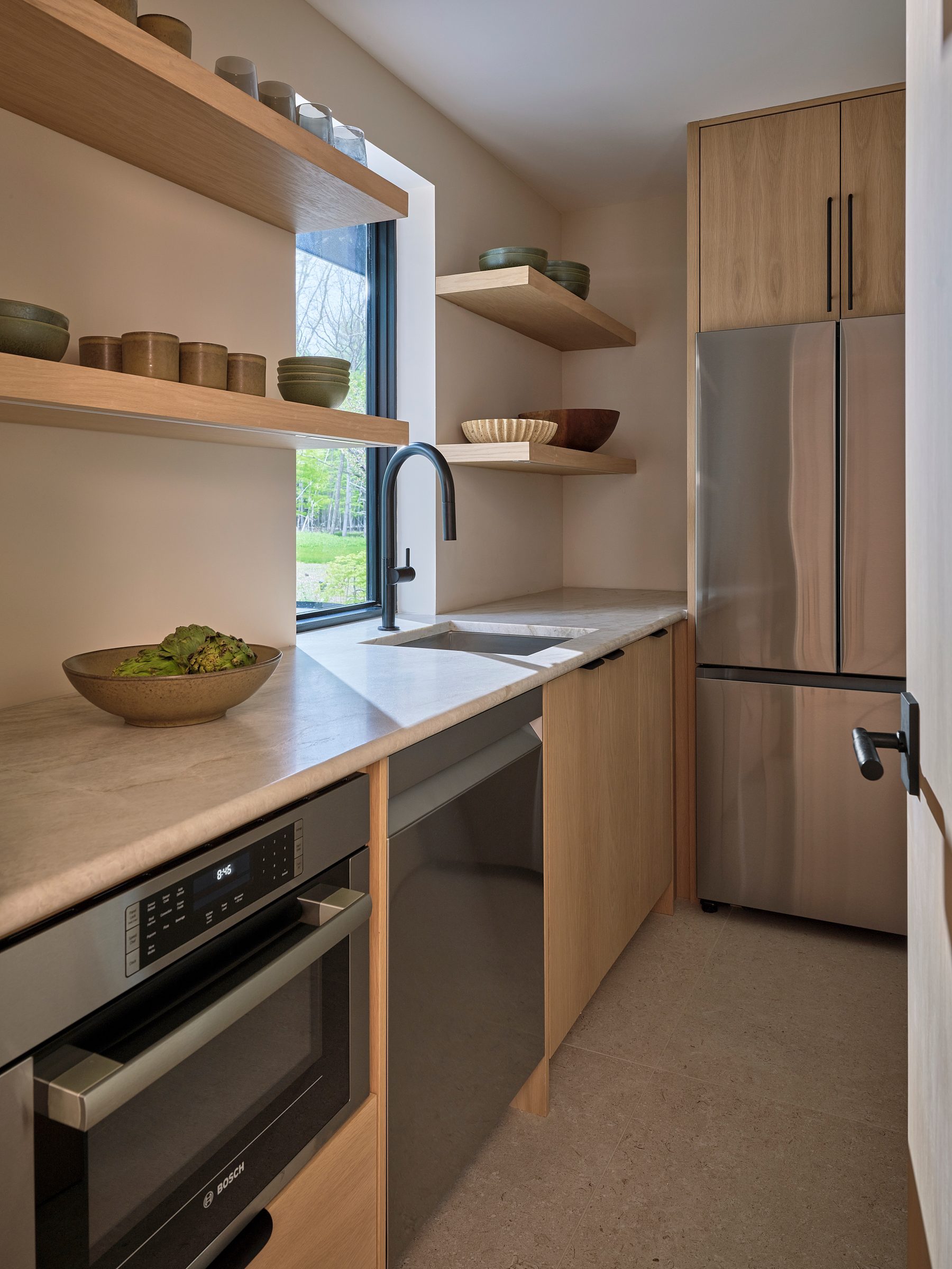 The butler's kitchen, with open oak shelving, a speed oven and refrigeration.
