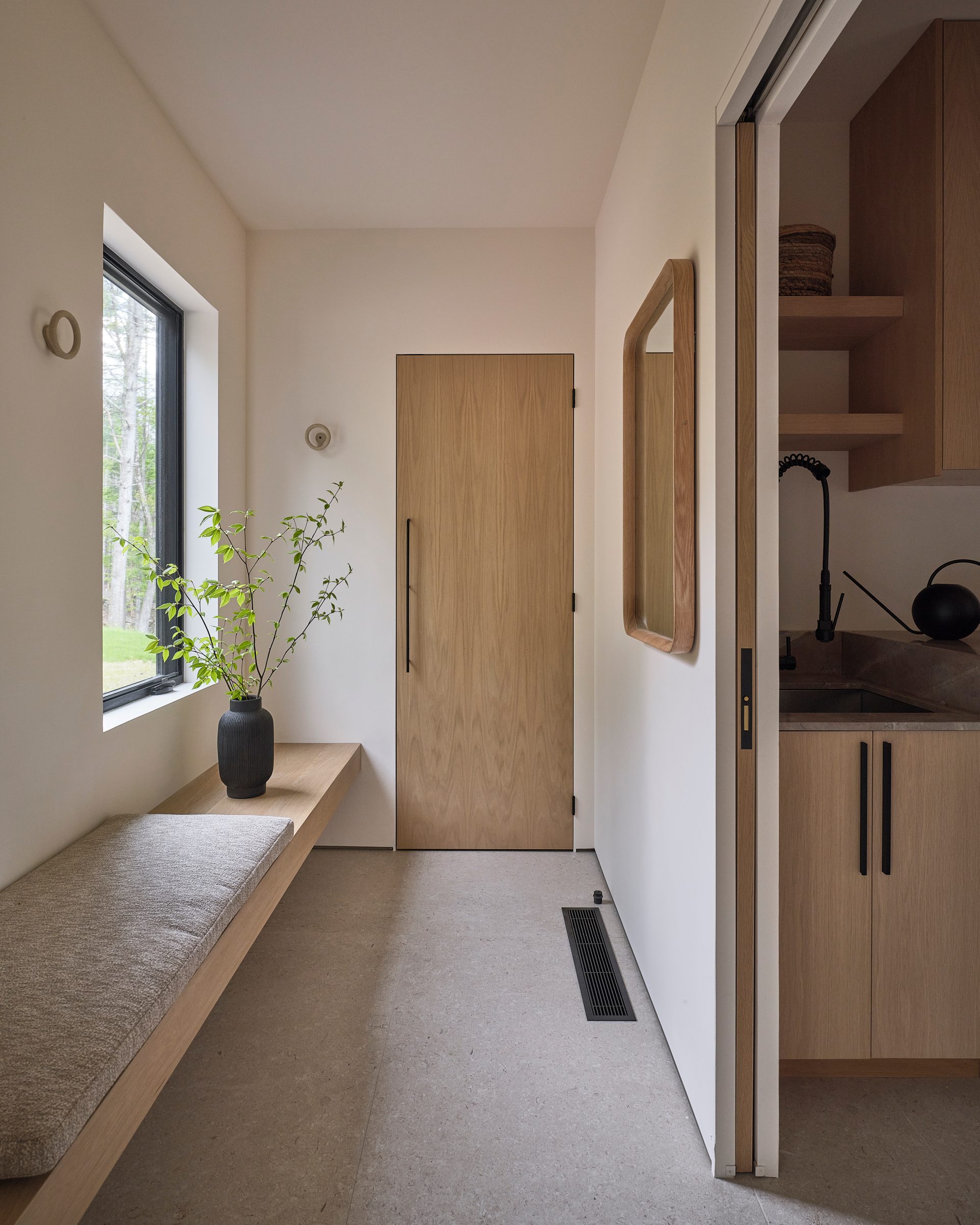 A hallway with a built-in bench and a window.
