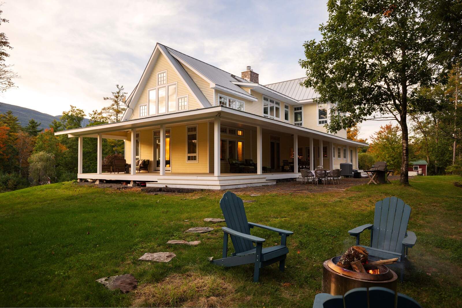 The wraparound porch and the lawn, chairs set out on the grass.