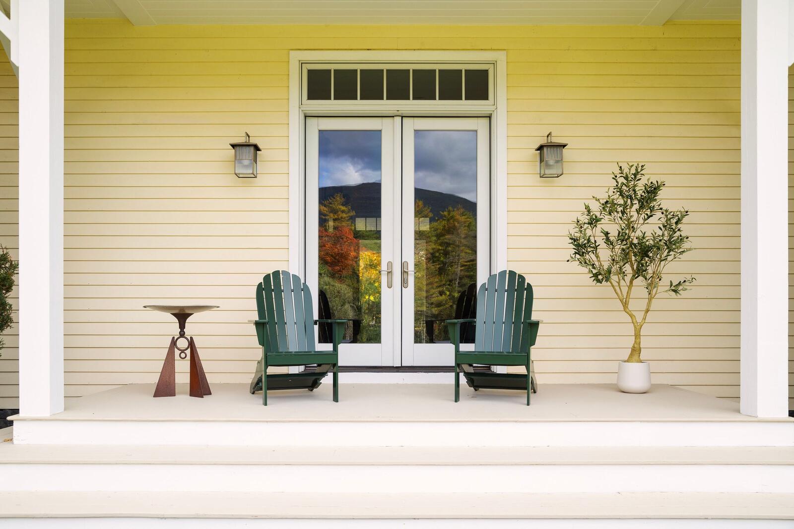 French doors onto the porch, two chairs beside them.