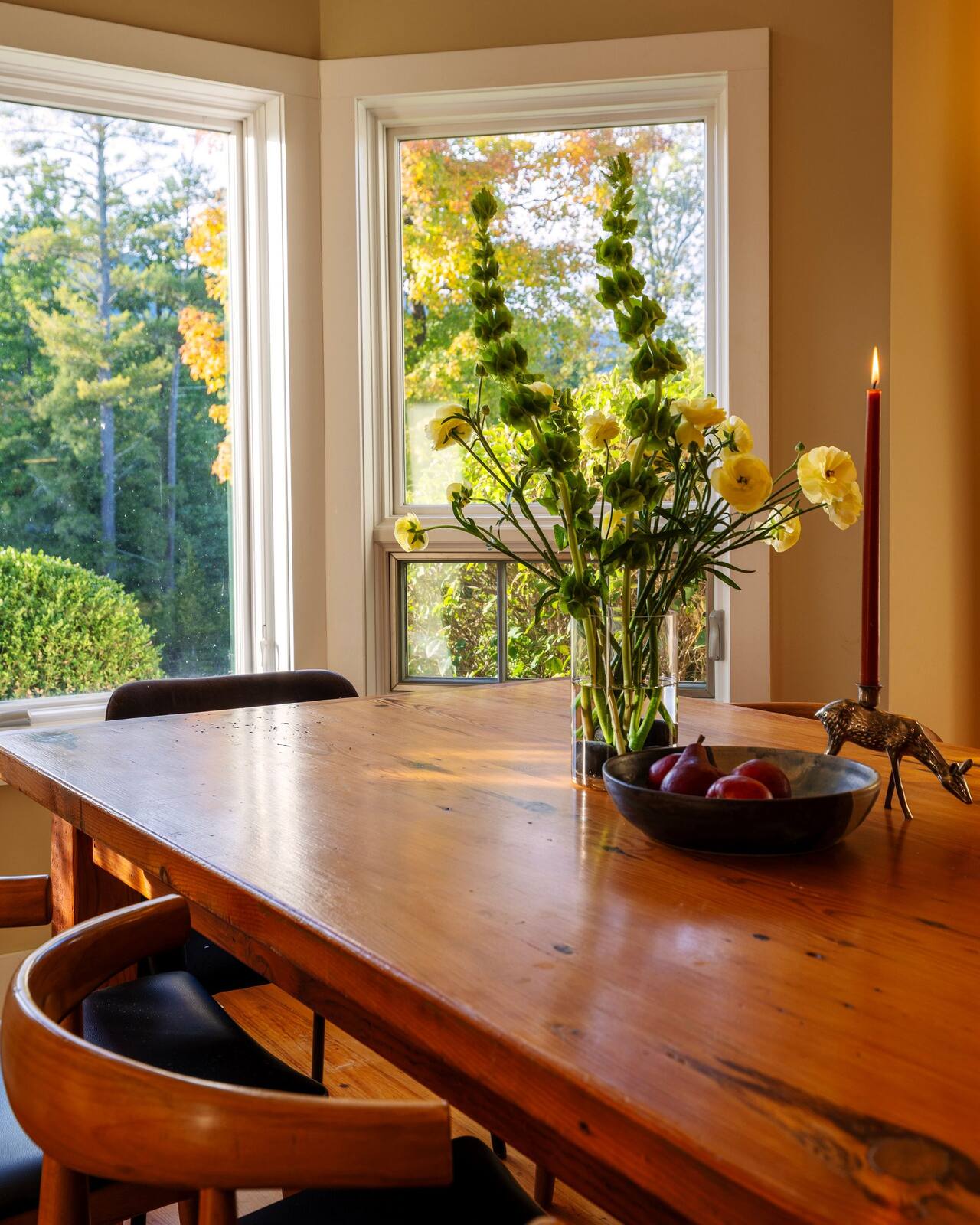 Flowers on the dining table, the bay windows behind.