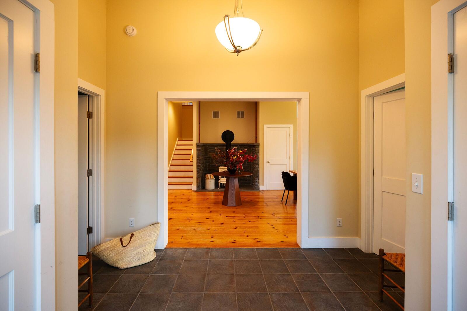 The foyer, a stair rising beyond it.