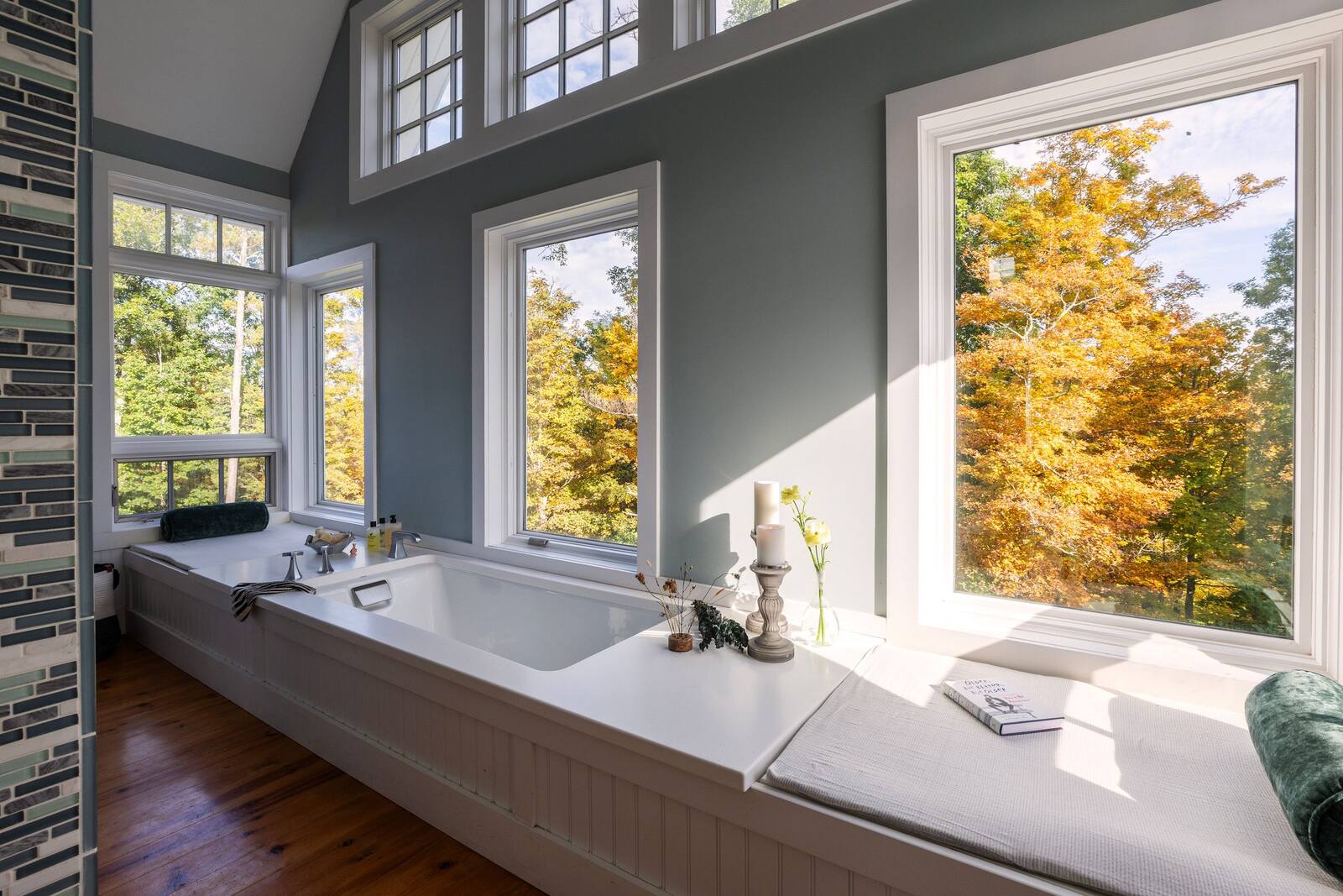 The soaking tub beneath tall windows.