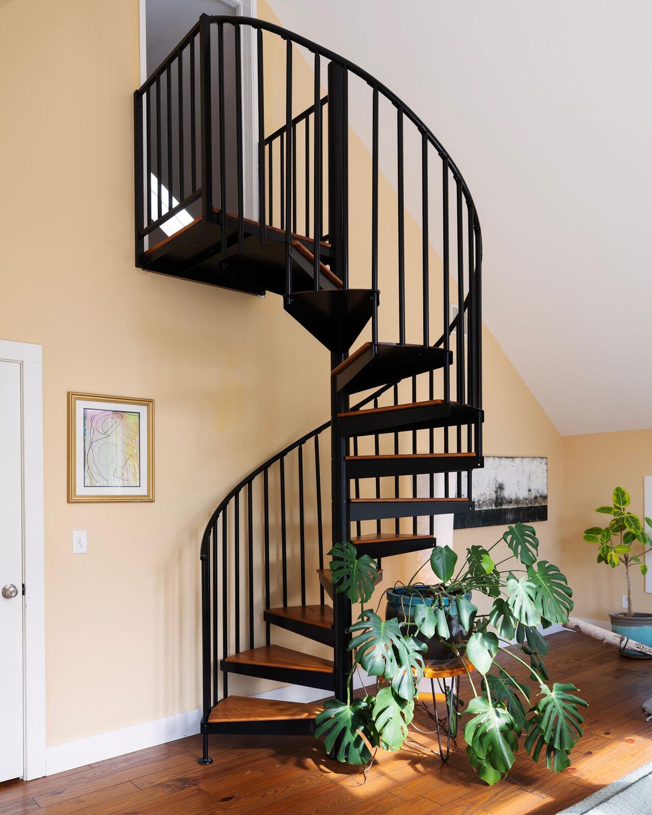 A spiral stair, black iron and wood.