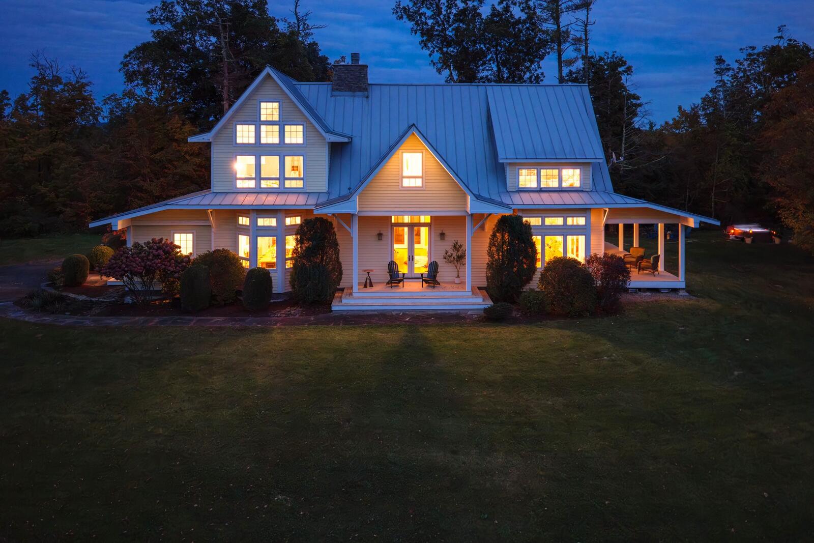 The house at dusk, every window lit.