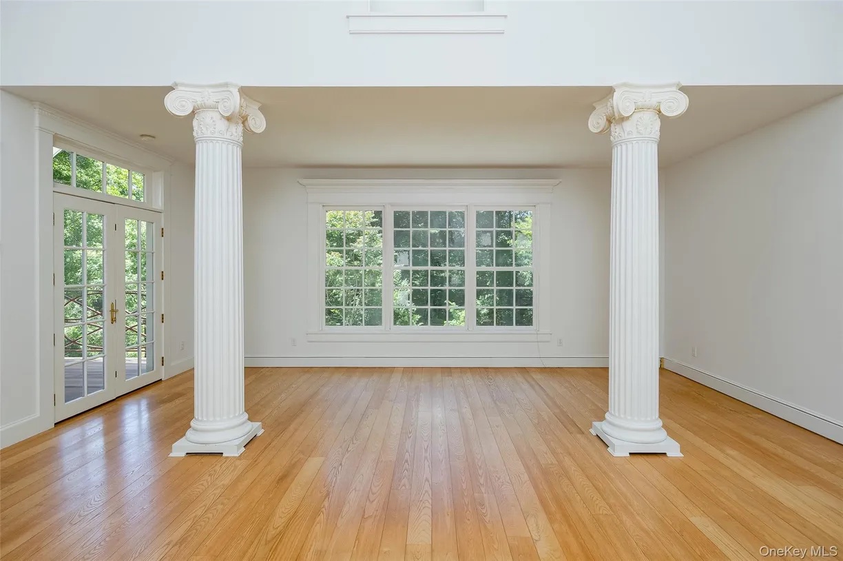 Empty columned great room before virtual staging