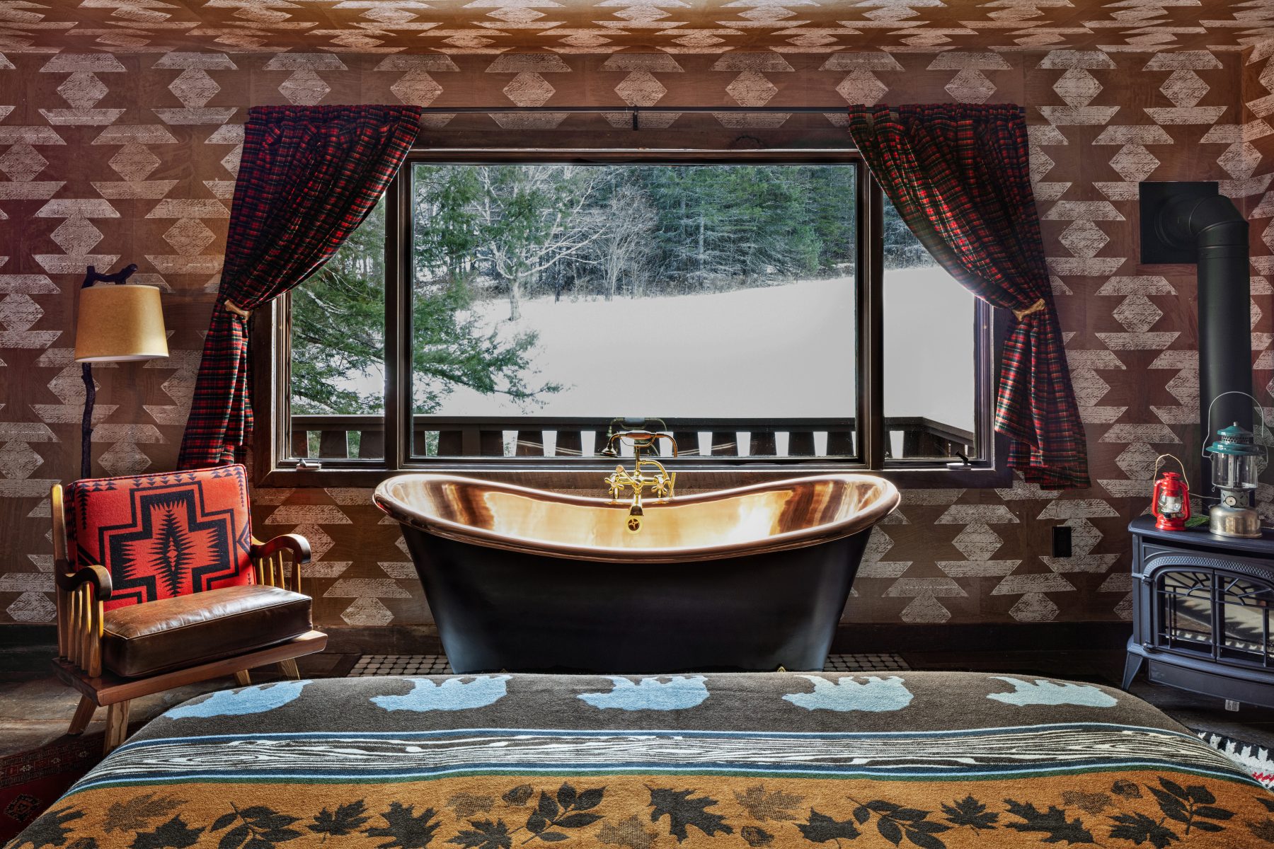 Urban Cowboy Catskills — copper soaking tub beneath a snow-framed window