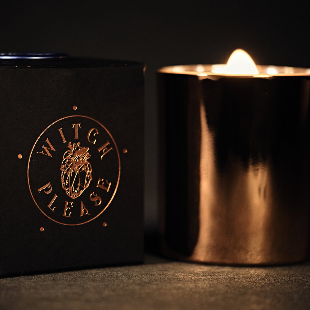 A Witch Please manifestation candle — a wax vessel with embedded quartz crystal visible at the bottom, hand-poured during a lunar event